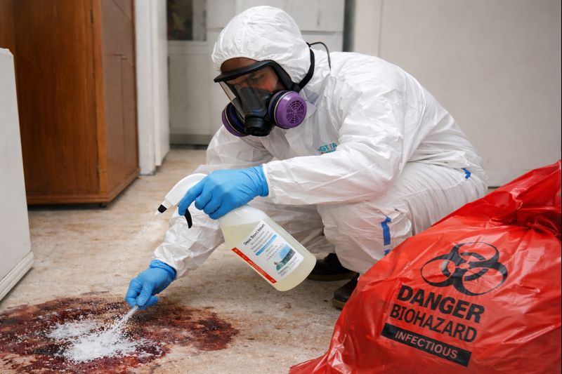 Professional biohazard cleanup technician performing decontamination with full PPE — GTA Restoration certified biohazard services in Toronto & GTA.
